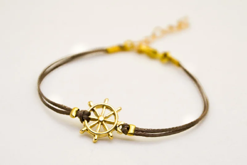 Brown cord bracelet with a 14k gold plated ship's wheel charm